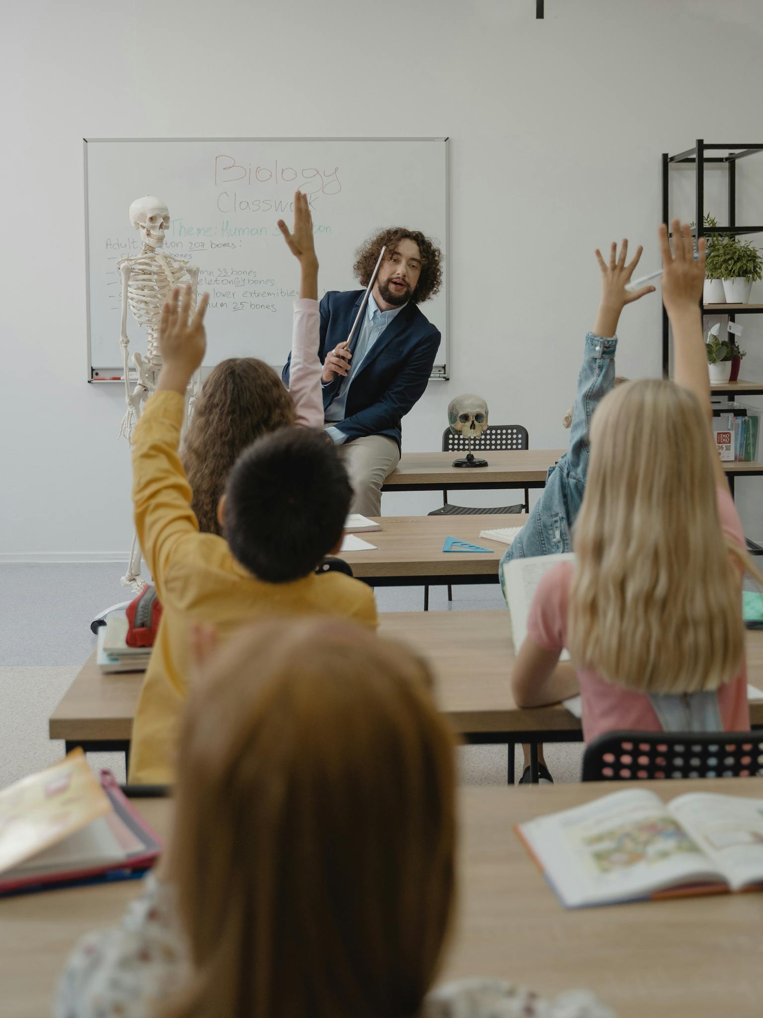 A classroom with a teacher and students actively participating in a lesson about biology.